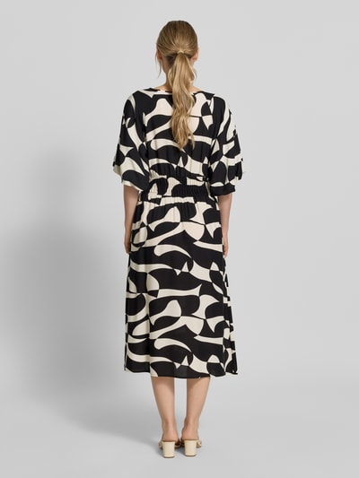 Frauenmodel trägt Soyaconcept Midikleid aus Reine Viskose, A-Linie, Allover-Look, Modell 'CHANISE', Ganzkörperansicht Rückansicht. Kontext: Damen Midikleid von Soyaconcept, Reine Viskose, A-Linie, Modell 'CHANISE', Allover-Look, Rundhalsausschnitt, Rückenlänge bei Größe S: 119 cm, Brustweite bei Größe S: 48 cm, Ärmellänge bei Größe S: 28 cm.