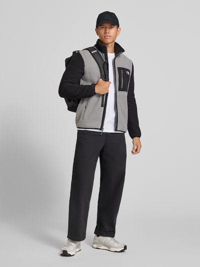 Männermodel trägt Fleecejacke mit Stehkragen Modell 'YUMIORI' von The North Face in Grau und Schwarz, lockere Passform, Ganzkörperansicht von vorne.