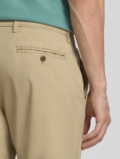 Männermodel trägt Slim Fit Chino mit Eingrifftaschen von GAP im Baumwoll-Elasthan-Mix, beige, Detailaufnahme Rückansicht.