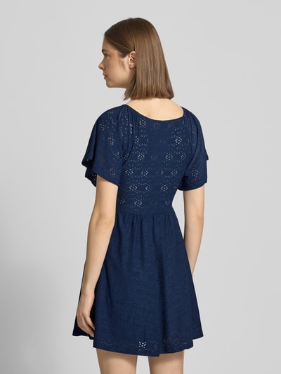 Vrouwenmodel draagt Only vrijetijdsjurk model 'Smilla' in donkerblauw met etskanteffect, getailleerde pasvorm, minilengte, korte mouw, rechte zoom. Ganzkörperansicht Rückansicht.