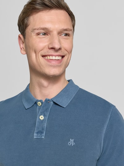 Männermodel trägt Regular Fit Poloshirt aus reiner Baumwolle von Marc O'Polo, Optik: Unifarben, Logo-Stitching, Nahaufnahme Oberkörper.