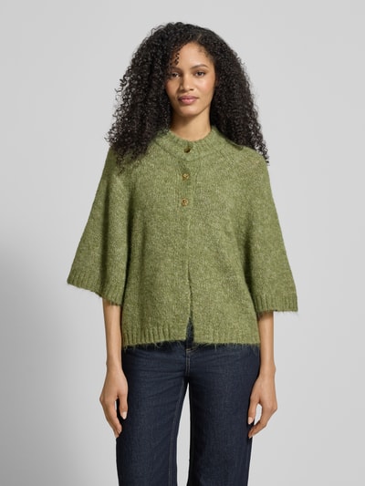 Frauenmodel trägt Strickjacke mit 1/2-Arm Modell 'Benutta Fluffy' von Neo Noir in grünem Material-Mix mit Baumwoll-Anteil, Relaxed-Fit, Rundhalsausschnitt und Knopfverschluss, Damen Strickjacke, Ganzkörperansicht von vorne.