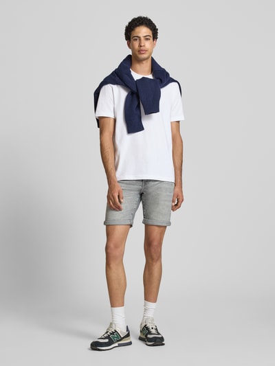 Männermodel trägt Regular Fit Jeansshorts aus Baumwoll-Mix Modell 'PLY MGD 8774' von Only & Sons, Denim-Optik, Label-Patch, 5-Pocket-Design, Twill, Ganzkörperansicht von vorne.
