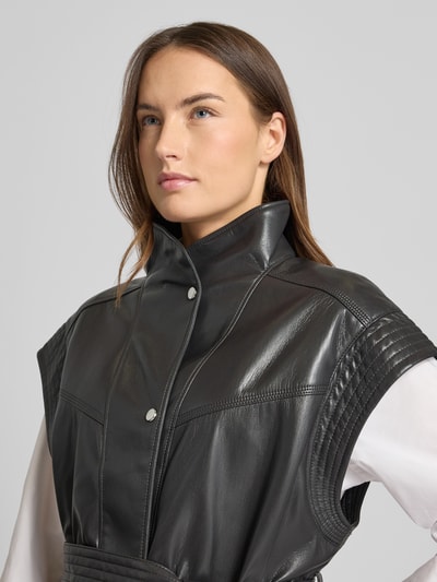 Frauenmodel trägt Regular Fit Weste mit Viskose-Anteil Modell 'JACARO' von BOSS Orange in Schwarz, Kunstleder mit Stehkragen, Nahaufnahme Oberkörper.