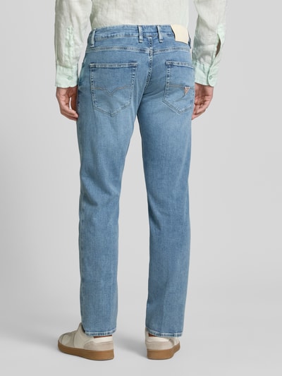 Männermodel trägt Straight Leg Jeans im 5-Pocket-Design Modell 'ANGELS' von Guess, hellblauer Denim, Ganzkörperansicht Rückansicht.