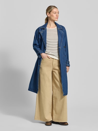 Frauenmodel trägt Jeansmantel mit Gürtel Modell 'HERA' von khujo aus Reine Baumwolle, Gerader-Schnitt, Zweireiher, Reverskragen, Rückenlänge 103 cm, Schulterbreite 44 cm, Brustweite 44 cm, Ärmellänge 57 cm, blaue und beigetöne, glatte Textur, Ganzkörperansicht von vorne.