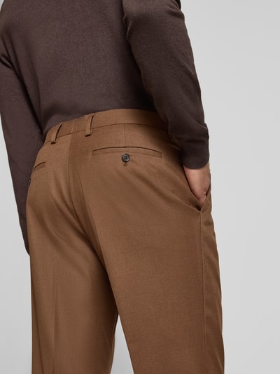 Männermodel trägt Straight Fit Hose mit Viskose-Anteil von MCNEAL in Braun mit Bügelfalten und Gesäßtaschen, Nahaufnahme Rückansicht.