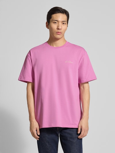 Mannenmodel draagt t-shirt met logoprint model 'Crew' van Les Deux, puur katoen, recht model, ronde hals, ruglengte maat M 74 cm, frontale volledige lichaamsopname.