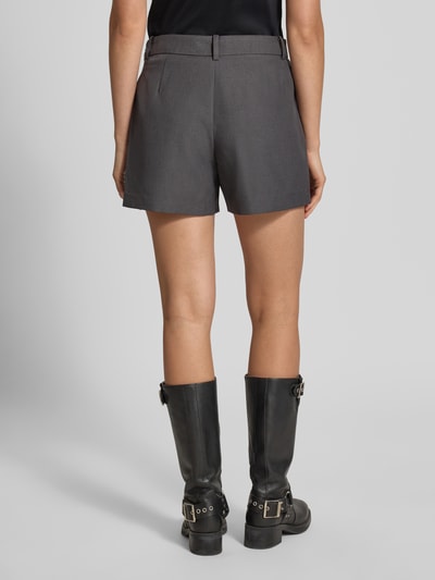 Männermodel trägt grauen Regular Fit Skort mit Gürtelschlaufen Modell 'LINDA' von ONLY, Damen Mini-Rock, Ganzkörperansicht Rückansicht.