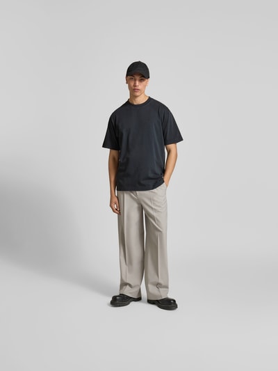 Männermodel trägt Regular Fit T-Shirt aus reiner Baumwolle von Closed in Used-Look mit Label-Print, Grau- und Beigetönen, Ganzkörperansicht von vorne. Herren T-Shirt mit Rundhalsausschnitt, Rückenlänge bei Größe M: 76 cm.