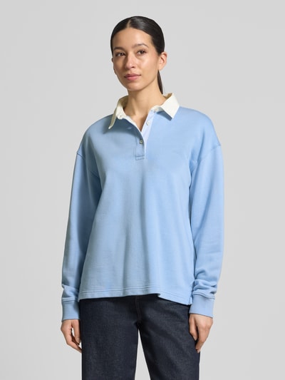 Frauenmodel trägt Longsleeve mit Polokragen und kurzer Knopfleiste von Gant, hellblau, Baumwoll-Mix, Loose Fit, Nahaufnahme Oberkörper.