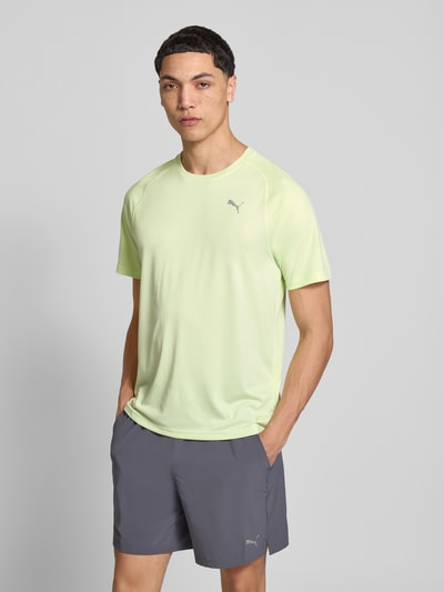 Mannelijk model draagt T-Shirt met Logo en ronde hals van PUMA PERFORMANCE in regular fit, lichtgroen, grijze short, vooraanzicht halflichaam.
