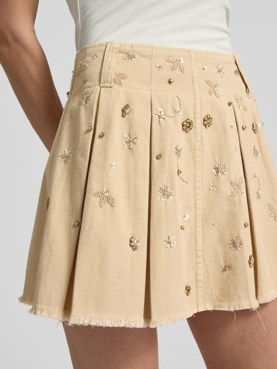 Frauenmodel trägt Faltenrock mit Pailletten, Perlen und Ziersteinbesatz von Liu Jo White, beige, reine Baumwolle, A-Linie, Detailaufnahme.