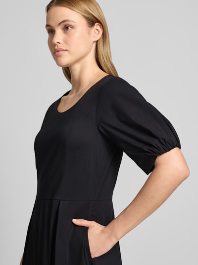 Vrouwenmodel draagt Midikleid met Raffungen van More & More in zwart katoenmix, getailleerde pasvorm, ronde hals, halflange mouwen, stolpplooien, detailopname bovenlichaam.