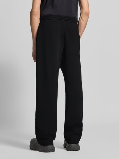 Männermodel trägt Sweatpants mit elastischem Bund von Moose Knuckles, Baumwollmischung, gerade Form, schwarze Farbe, Ganzkörperansicht Rückansicht.