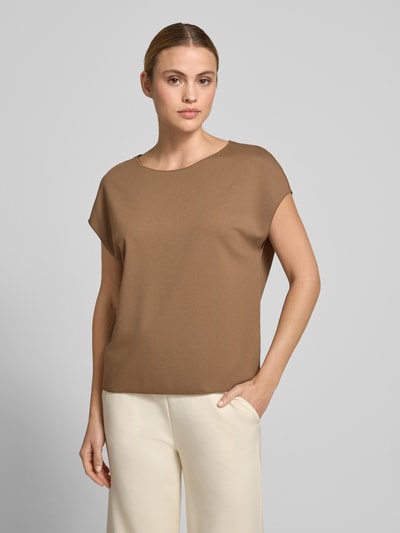 Kobiecy model nosi damski t-shirt z mieszanki wiskozy z dodatkiem streczu, krój regular fit, model 'Uvalerie' od Someday, okrągły dekolt, krótkie rękawy, długość tyłu w rozmiarze 36: 57 cm, brązowy top, kremowe spodnie, gładka tekstura, zdjęcie całej sylwetki z przodu