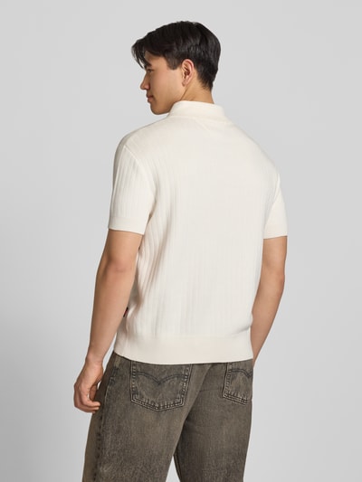 Männermodel trägt Regular Fit Poloshirt aus reiner Baumwolle von Tommy Jeans in Two-Tone-Optik, Strick, Rückansicht Ganzkörperansicht.