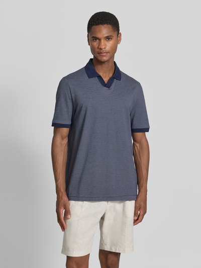 Männermodel trägt Regular Fit Poloshirt aus Baumwolle mit V-Ausschnitt von MAERZ Muenchen, dunkelblau, Label-Detail, Ganzkörperansicht von vorne. Rückenlänge bei Größe 50: 71 cm.