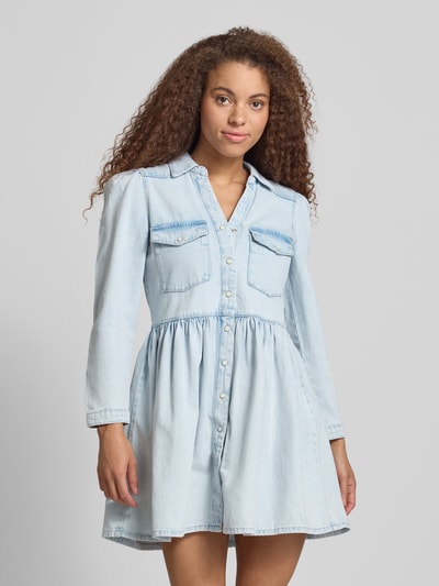 Frauenmodel trägt Mini-Jeanskleid aus reiner Baumwolle Modell 'CYRUS' von Only in Denim-Optik, V-Ausschnitt, Knopfleiste, Langarm, Ausgestellt, Ganzkörperansicht von vorne.