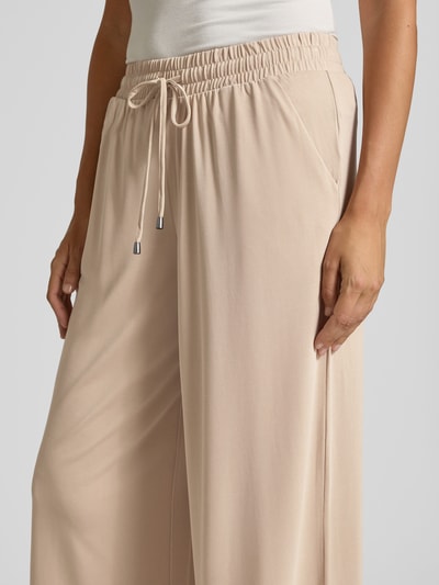 Vrouwenmodel draagt Straight Fit Stoffhose in verkürzter Passform van Christian Berg Woman, modalmix, elastische band met tunnelkoord, beige, detailopname taille.