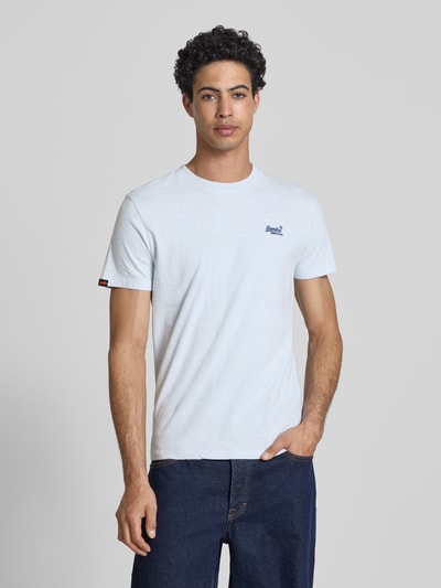 Männermodel trägt Regular Fit T-Shirt mit Logo-Stitching von Superdry in Hellgrau, reine Baumwolle, Rundhalsausschnitt, Ganzkörperansicht von vorne.