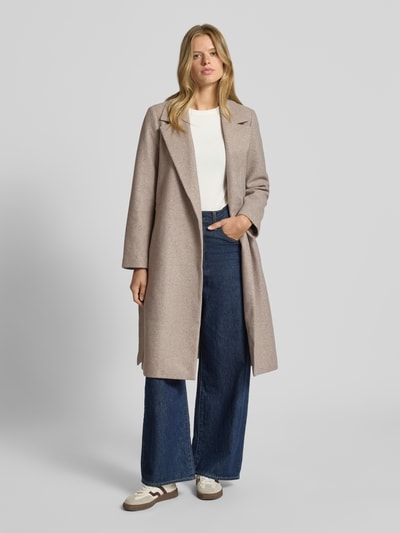 Modelka nosi Regular Fit Trenchcoat mit Reverskragen Modell 'ALVILDA LIFE' od Only, jednolity/melange, pasek, długi rękaw, kieszenie, krój regular fit, długość całkowita 106 cm w rozmiarze S, szerokość w rozmiarze S: 54 cm, szerokość ramion w rozmiarze S: 39 cm, długość rękawa w rozmiarze S: 62 cm; widok całej sylwetki z przodu.