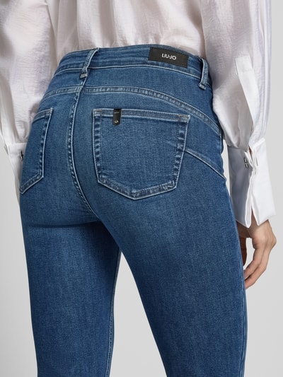 Frauenmodel trägt Flared Fit Jeans aus mieszanka bawełny i lyocellu z obszyciem kamieniami stras, 5 kieszeni, Liu Jo White, Model 'Princess', Skrócony, Ganzkörperansicht Rückansicht
