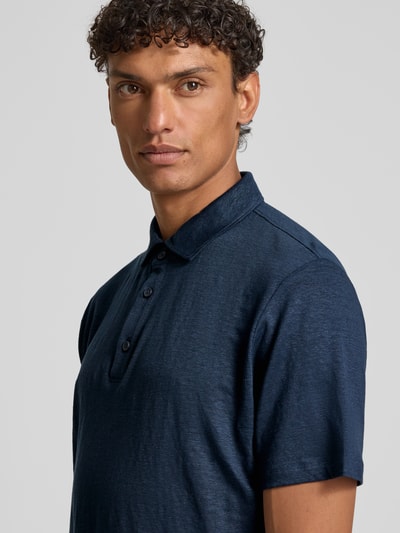 Männermodel trägt Slim Fit Poloshirt aus Leinen-Elasthan-Mix von OLYMP Level Five in Dunkelblau, Nahaufnahme Oberkörper.