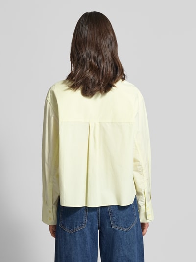 Männermodel trägt Boxy Fit Bluse mit verdeckter Knopfleiste Modell 'BLAIRE' von Copenhagen Muse aus reiner Baumwolle, Hemdblusenkragen, Rückenlänge w rozmiarze S/M: 57 cm, jasny żółty, biała, tekstura gładka, prostokątne formy, Ganzkörperansicht Rückansicht.