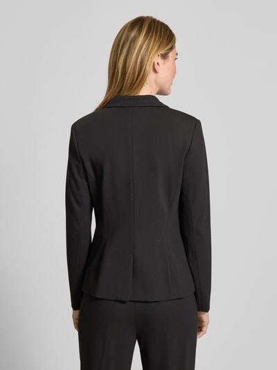 Frauenmodel trägt Blazer mit Reverskragen von Comma, schwarzer Viskose-Mix mit Stretch-Anteil, Slim Fit, Rückenansicht Ganzkörperansicht. Rückenlänge 60 cm, Brustweite 43 cm, Ärmellänge 61 cm, Knopfverschluss, Nahtreißverschlusstaschen.