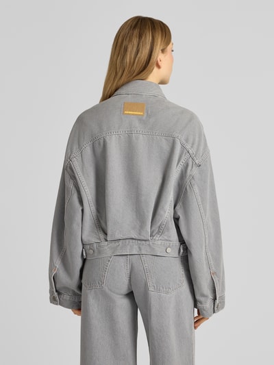 Frauenmodel trägt Oversized Jeansjacke aus Lyocell-Baumwoll-Mix Modell 'PAASITHE' von Armedangels in grauer Denim-Optik, Ganzkörperansicht Rückansicht