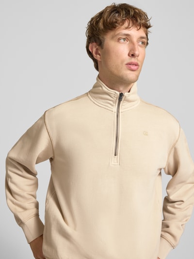 Männermodel trägt beiges Regular Fit Sweatshirt aus reiner Baumwolle von G-Star RAW, glatte Struktur, Nahaufnahme Oberkörper.