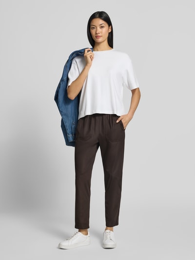 Frauenmodel trägt Hose mit elastischem Bund und Eingrifftaschen von Marc Cain in Regular Fit, dunklem Farbton, Material-Mix mit Stretch-Anteil, Ganzkörperansicht von vorne.