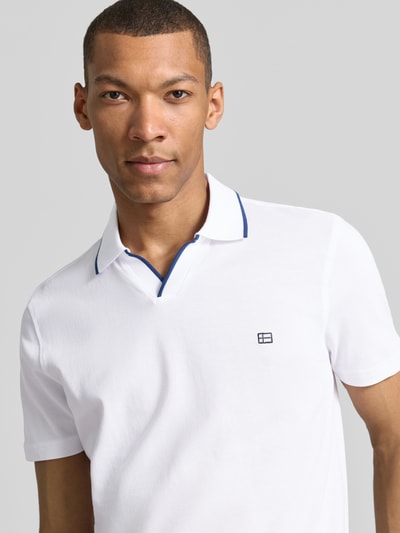 Męski model nosi Modern Fit Poloshirt mit Logo-Stitching od Christian Berg Men, biała bawełna, logo, kołnierzyk, krój modern fit, zbliżenie na górną część ciała.