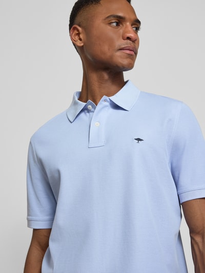 Męski model nosi Regular Fit Poloshirt mit Logo-Stitching od Fynch-Hatton, jasnoniebieski, czysta bawełna, krótki rękaw, kołnierzyk polo, krój regular fit, haftowane logo, długość tyłu w rozmiarze M: 70 cm, zbliżenie na górną część ciała