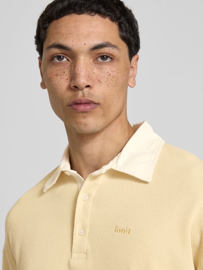 Männermodel trägt Relaxed Fit Sweatshirt mit Polokragen von Forét aus Reine Baumwolle mit Logo-Stitching und Strukturmuster, Nahaufnahme Oberkörper.