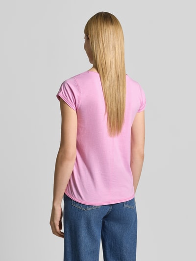 Frauenmodel trägt T-Shirt mit Statement-Print und Rundhalsausschnitt von Christian Berg Woman aus rosa Baumwolle, Regular Fit, Rollsaum, Rückenlänge 60 cm, kombiniert mit blauer Jeans, Ganzkörperansicht Rückansicht.
