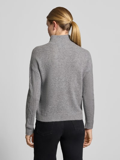 Frauenmodel trägt Kaschmirpullover mit Zopfmuster von Christian Berg Woman in Grau, gerader Schnitt, Stehkragen, Rückenansicht, Ganzkörperansicht Rückansicht.