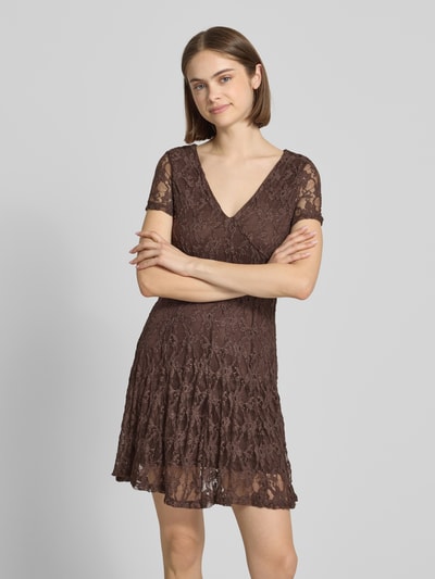 Frauenmodel trägt Slim Fit Minikleid aus Spitze Modell 'ALBINA' von Only in Braun mit V-Ausschnitt, Spitzenmuster, kurzarm, Mini, Ganzkörperansicht von vorne.