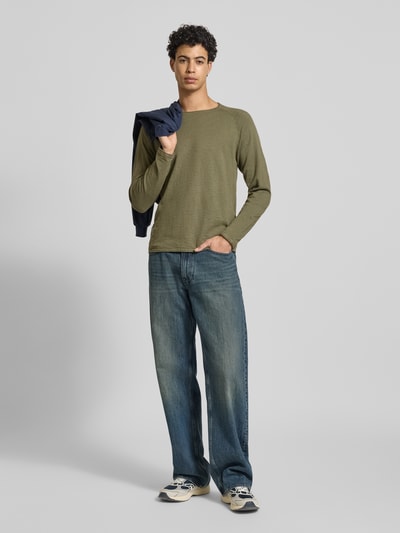 Männermodel trägt Regular Fit Longsleeve mit Logo-Patch Modell 'Breeze' von JACK & JONES, reine Baumwolle, Strick-Optik, Ganzkörperansicht von vorne.