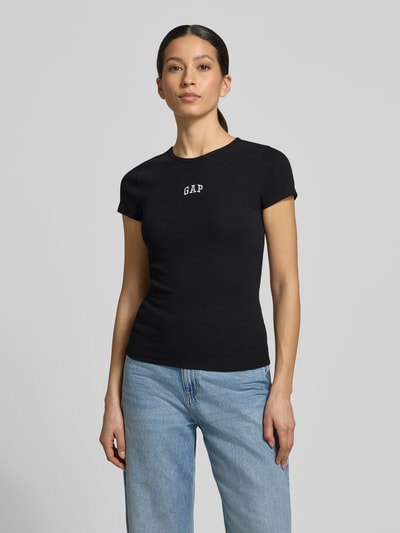 Frauenmodel trägt T-Shirt in Ripp-Optik mit Logo von GAP, schwarz, Slim Fit aus Baumwoll-Mix mit Modal, Rundhalsausschnitt, Nahaufnahme Oberkörper.