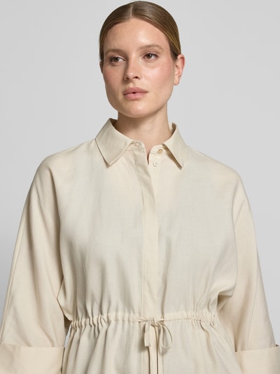 Frauenmodel trägt Relaxed Fit Bluse aus Lyocell-Mix mit 3/4-Arm von Comma, Hemdblusenkragen, Tunnelzug, glatter beigefarbener Stoff, Nahaufnahme Oberkörper.