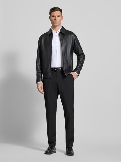 Männermodel trägt Slim Fit Freizeithemd aus reiner Baumwolle Modell 'KENNO' von HUGO in Weiß mit feinem Strukturmuster, Ganzkörperansicht von vorne.