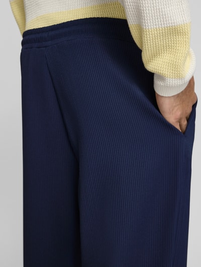 Männermodel trägt Hose mit elastischem Bund in Plissee-Optik von REVIEW, dunkelblau, Material-Mix mit Stretch-Anteil, Nahaufnahme Oberschenkel.