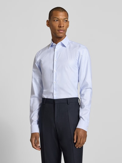 Männermodel trägt hellblaues Slim Fit Businesshemd mit extra langem Arm von Jake*s, glatte Textur, Ganzkörperansicht von vorne.