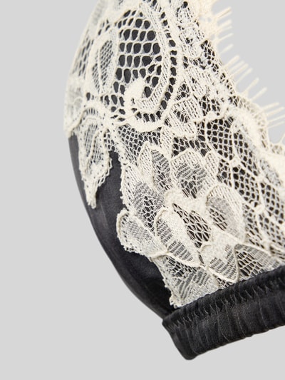 Produktfoto, BH mit zarter Spitzenapplikation von JAKE*S WOMAN CASUAL, schwarze Basis mit feinem cremefarbenem Spitzenbesatz, Detailaufnahme, ohne Bügel, verstellbare Spaghettiträger, Haken-und-Ösen-Verschluss.