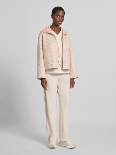 Frauenmodel trägt Jacke im Allover-Look mit Stehkragen von Marc Cain aus Baumwoll-Mix, Regular Fit, sanfte Creme- und Rosatöne, Ganzkörperansicht von vorne.