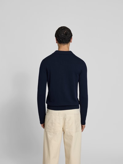 Männermodel trägt Slim Fit Poloshirt aus Woll-Mix von Filippa K, dunkelblau, Strick-Optik, langärmelig, Ganzkörperansicht Rückansicht