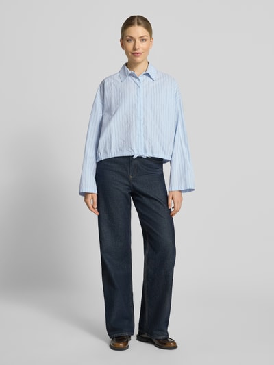 Vrouwenmodel draagt Boxy Fit blouse met overhemdkraag en verborgen knoopsluiting Model 'FIONEL' van DRYKORN, puur katoen, tunnelkoord, Ruglengte maat 36: 54 cm, mouwlengte maat 36: 50 cm, lichtblauw met fijne strepen, textuur glad, voorkant gehele lichaam