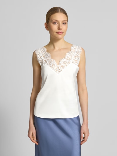Vrouwenmodel draagt Blusentop mit Spitzenbesatz van Christian Berg Woman Selection in wit met V-hals en kanten details, regular fit, materiaalmix met stretch, ruglengte 56 cm, voorkant bovenlichaam close-up.